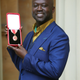 Sir David Adjaye poses after he was Knighted by the Duke of Cambridge during an Investiture ceremony at Buckingham Palace on May 12, 2017 in London, England.